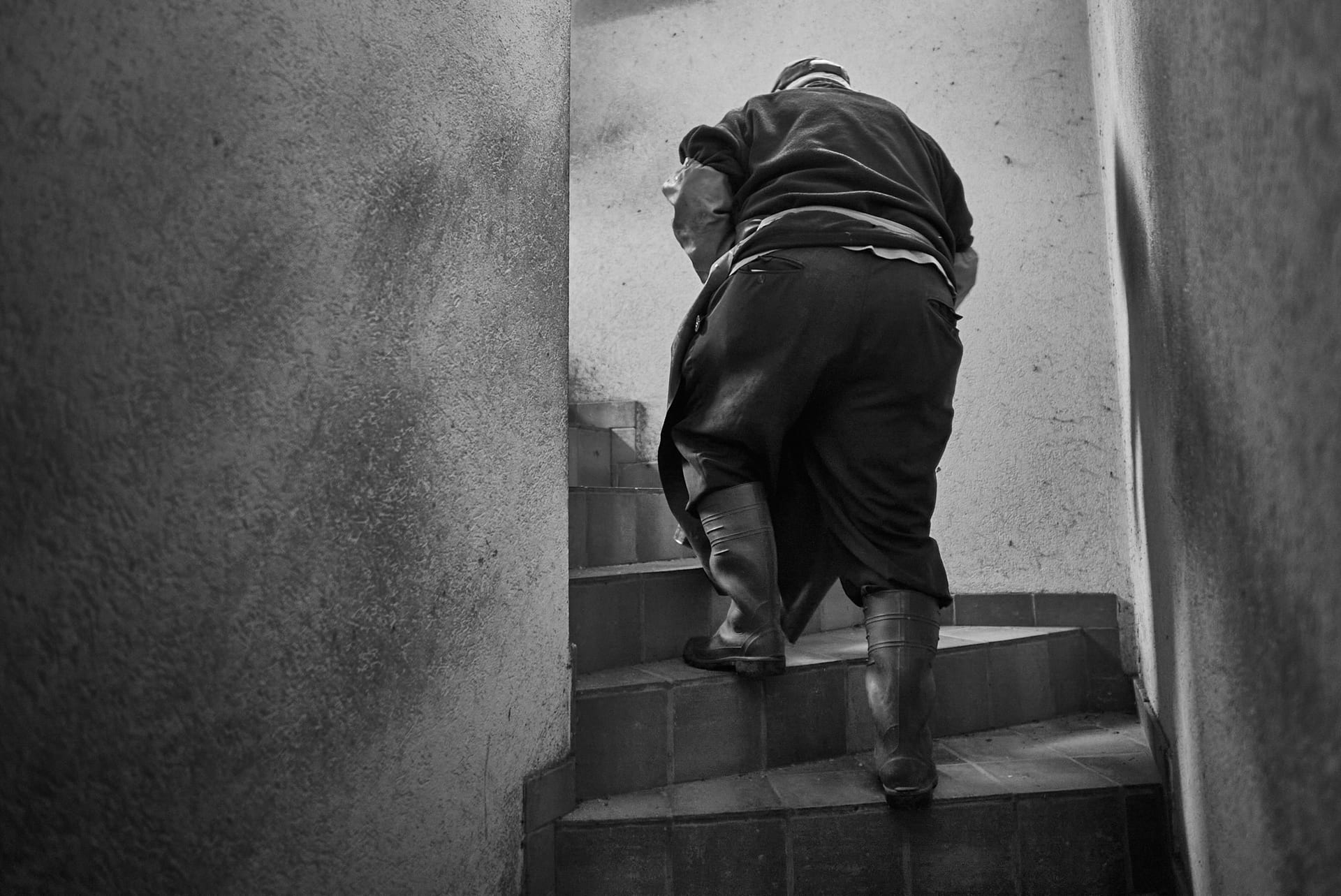 Ein Fischer steigt in Stiefeln eine schmale Treppe hinauf